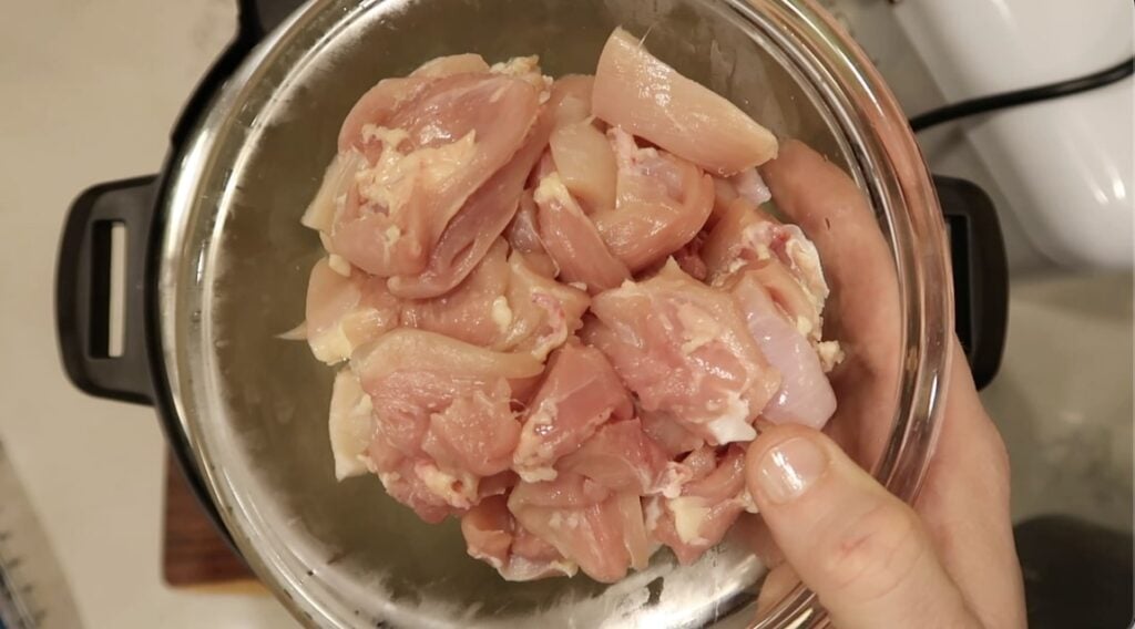 Adding diced boneless, skinless chicken thighs and/or breasts to the pot.